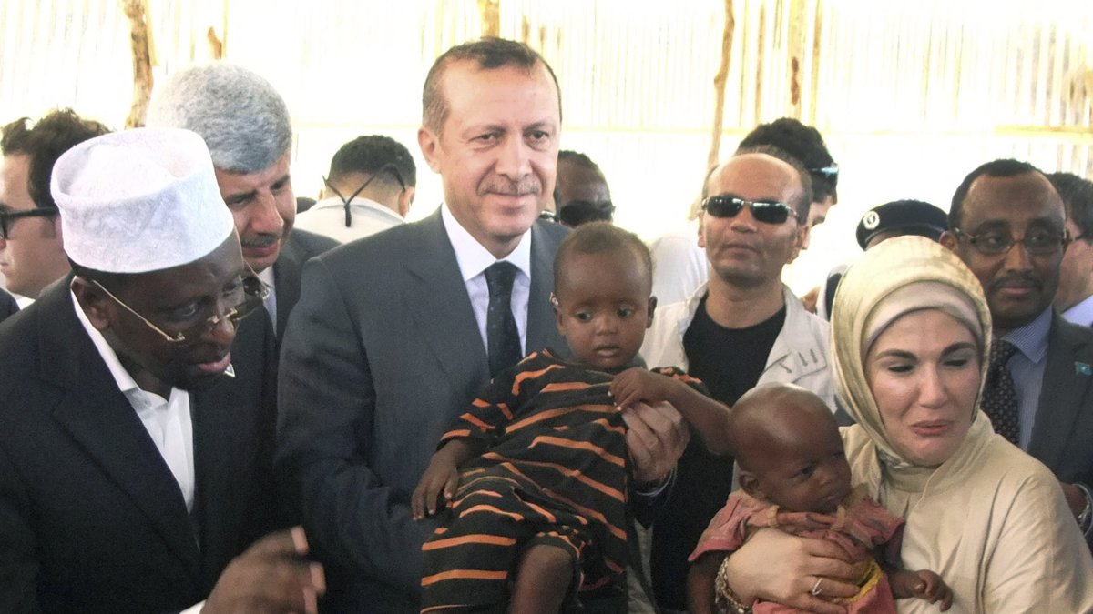 Then-Prime Minister Recep Tayyip Erdoğan and first lady Emine Erdoğan hold refugee children during a visit to a refugee camp, Mogadishu, Somalia, Aug. 19, 2011. (AP Photo)