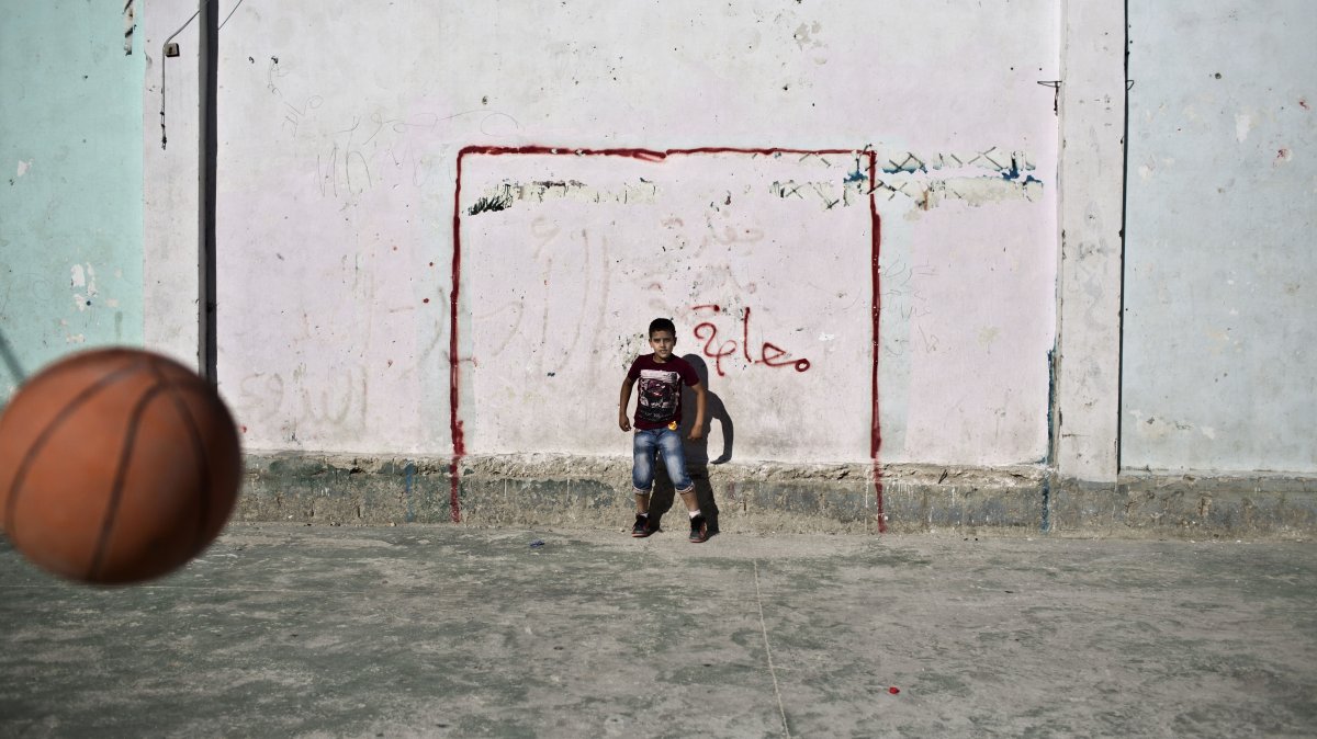 Palestinian boys use a basketball to play football in the occupied West Bank, Palestine, June 13, 2014. (AP Photo)