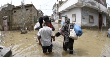 People wade through rainwater after torrential rains in Karachi, Pakistan, Aug. 20, 2025. (EPA Photo)