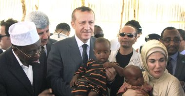 Then-Prime Minister Recep Tayyip Erdoğan and first lady Emine Erdoğan hold refugee children during a visit to a refugee camp, Mogadishu, Somalia, Aug. 19, 2011. (AP Photo)