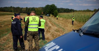 Police and territorial defense troops secure the area after an unidentified object fell and exploded in a cornfield overnight, according to Polish authorities, in the village of Osiny, eastern Poland, Aug. 20, 2025. (Reuters Photo)