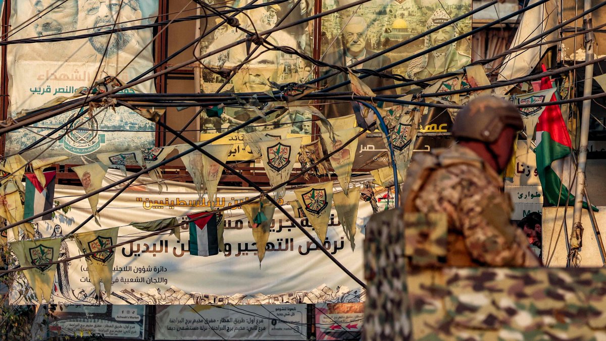 Flags of the Palestinian Fatah movement and images of Palestinian politicians are displayed behind a Lebanese army soldier manning a turret in an armored personnel carrier stationed at the Burj al-Barajneh camp for Palestinian refugees in Beirut&#039;s southern suburbs, Aug. 21, 2025. (AFP Photo)