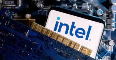 A smartphone with an Intel logo is displayed on a computer motherboard in this illustration, March 6, 2023. (Reuters Photo)