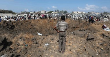 A displaced Palestinian inspects an impact crater caused by an Israeli strike, in Deir el-Balah in the central Gaza Strip, Palestine, Aug. 21, 2025. (AFP Photo)