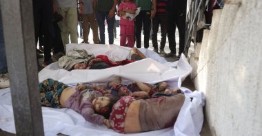 Palestinians stand over the bodies of children from the Irhim family, killed in an early morning Israeli strike on the Zaitoun district, at Gaza City&#039;s Al-Shifa hospital, Aug.11, 2025. (AFP Photo)