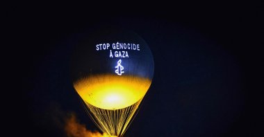 A message reading &quot;Stop genocide in Gaza&quot; is projected onto the Paris 2024 Olympic cauldron as it flies above the Tuileries Gardens during an action by Amnesty International, Paris, France, July 26, 2025. (AFP Photo)