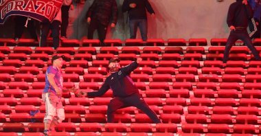 A fan of Universidad de Chile prepares to throw a stone during the interruption of the Copa Sudamericana round of 16 second leg football match between Argentina&#039;s Independiente and Chile&#039;s Universidad de Chile at the Libertadores de America stadium, Avellaneda, Buenos Aires, Argentina, Aug. 20, 2025. (AFP Photo)