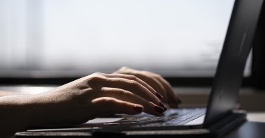 This photo shows a person typing on a laptop on a train, New Jersey, U.S., May 18, 2021. (AP Photo)