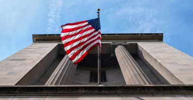 The American flag flies outside the Department of Justice in Washington, Thursday, Aug. 14, 2025. (AP Photo)