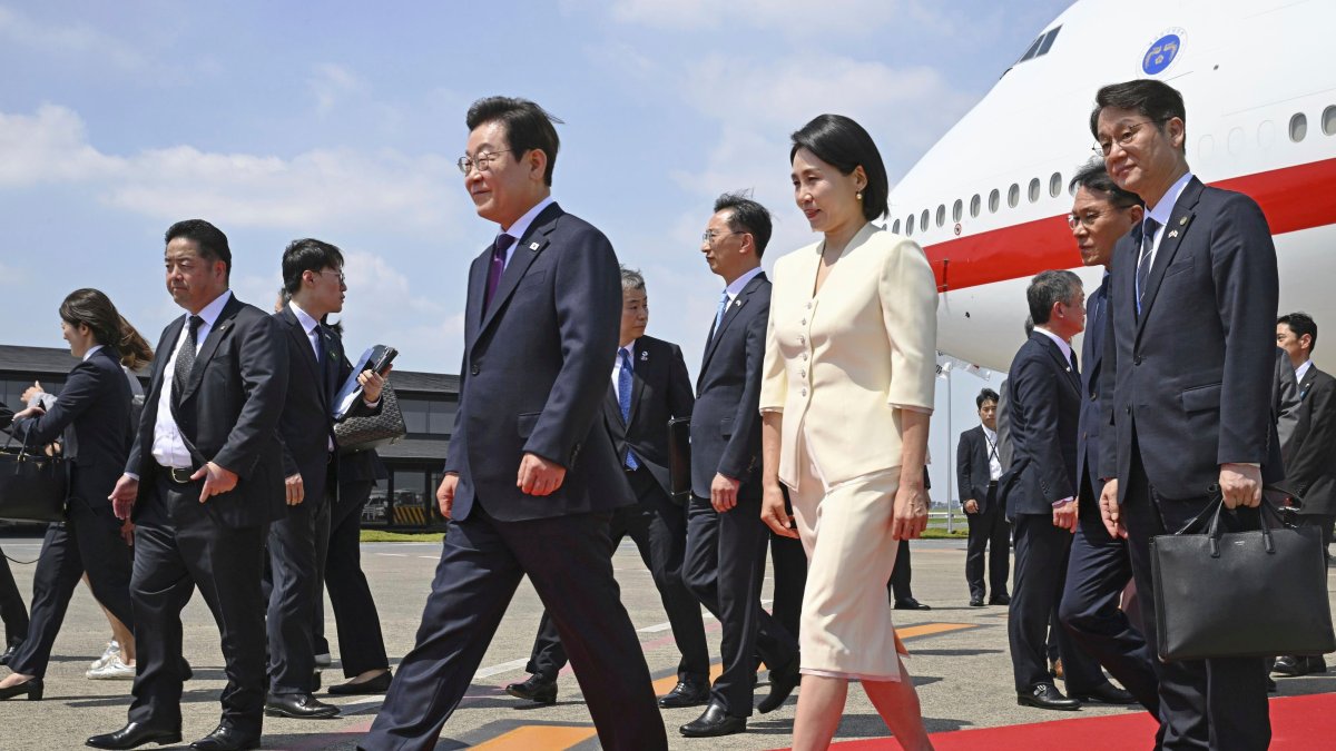 South Korean President Lee Jae Myung, center left, and his wife Kim Hea Kyung, center right, arrive at the Haneda airport in Tokyo, Japan, Aug. 23, 2025. (AP Photo)