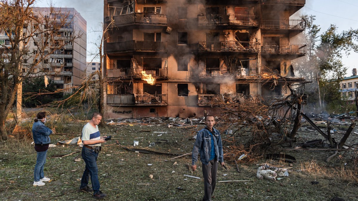 Local residents look on as smoke rises from a heavily damaged residential building following a Russian strike in the town of Kostiantynivka, Donetsk region, Ukraine, Aug. 22, 2025. (AA Photo)
