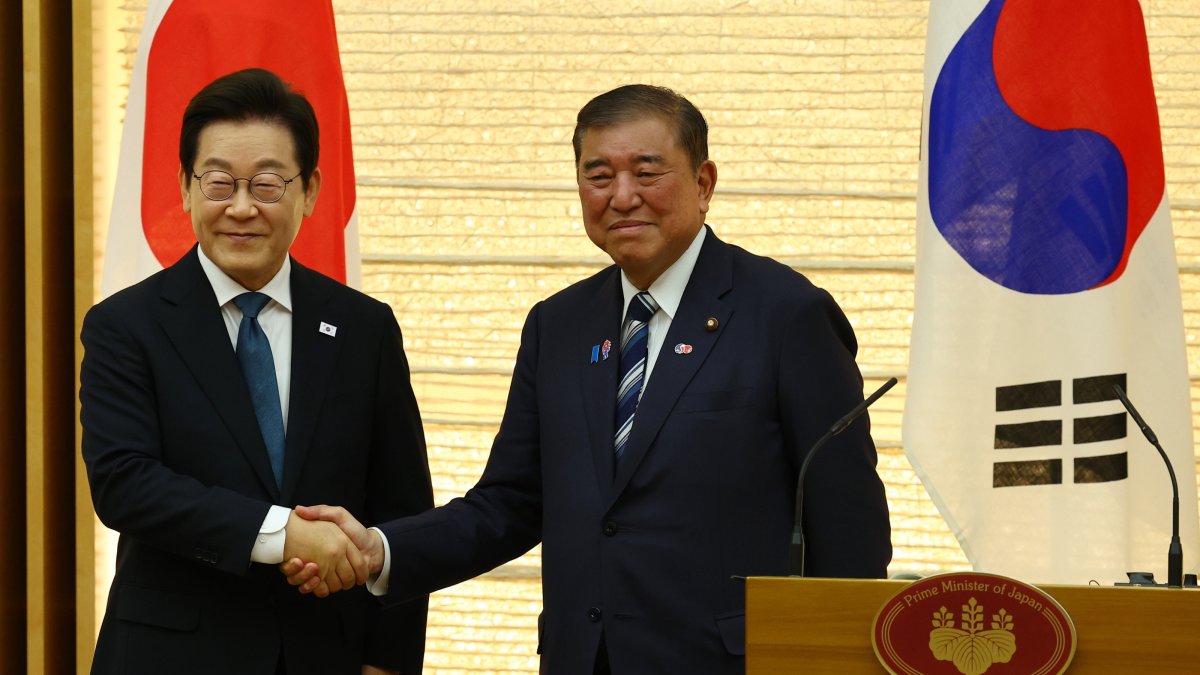 South Korean President Lee Jae Myung (L) and  Japan's Prime Minister Shigeru Ishiba shake hands at joint press announcement after the summit in Tokyo, Japan, Aug. 23, 2025. (EPA Photo)