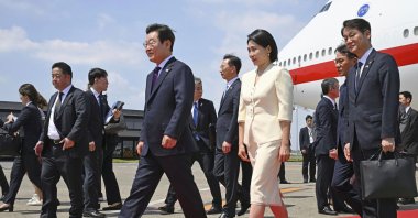 South Korean President Lee Jae Myung, center left, and his wife Kim Hea Kyung, center right, arrive at the Haneda airport in Tokyo, Japan, Aug. 23, 2025. (AP Photo)