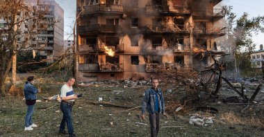 Local residents look on as smoke rises from a heavily damaged residential building following a Russian strike in the town of Kostiantynivka, Donetsk region, Ukraine, Aug. 22, 2025. (AA Photo)