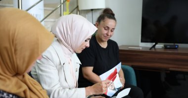 Family and Social Policies Minister Mahinur Özdemir Göktaş (C) presents a letter by the president explaining the terror-free Türkiye plan to the family of a martyr, Yalova, western Türkiye, Aug. 8, 2025. (AA Photo)