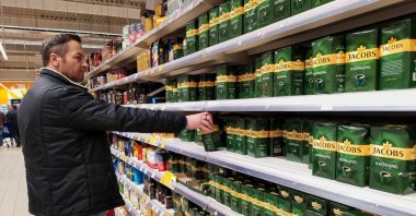 A man is taking a Jacobs coffee box from the store shelf in this undated photo. (Shutterstock Photo)