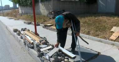 Ilyas Tok works on building benches at a bus stop in Avcılar, Istanbul, Türkiye, Aug. 25, 2025. (DHA Photo)
