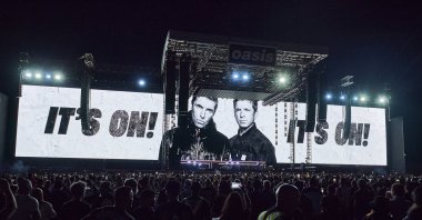 Liam Gallagher (L) and Noel Gallagher of Oasis are shown on video screens as they perform during their reunion tour in Toronto, Canada, Aug. 24, 2025. (AP Photo)