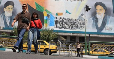 Iranians walk near a wall painting of Iran&#039;s supreme leader Ayatollah Ali Khamenei (Top L) and Iranian late supreme leader Ayatollah Ruhollah Khomeini, in Tehran, Iran, Aug. 18, 2025. (EPA Photo)