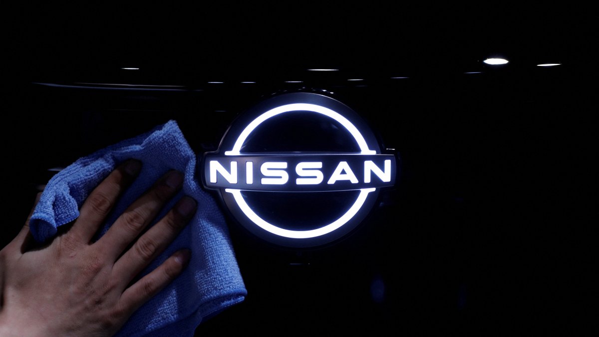 A man wipes the logo of Nissan Motor on the Ariya all-battery SUV during a press preview at the Nissan Pavilion, Yokohama, south of Tokyo, Japan, July 14, 2020. (Reuters Photo)