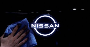 A man wipes the logo of Nissan Motor on the Ariya all-battery SUV during a press preview at the Nissan Pavilion, Yokohama, south of Tokyo, Japan, July 14, 2020. (Reuters Photo)