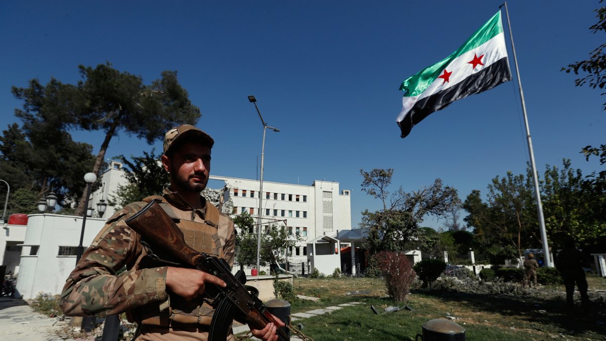 Syrian soldiers raise the Syrian national flag in front of the Syrian Defense Ministry building, heavily damaged by Israeli airstrikes, in Damascus, Syria, July 19, 2025. (AP Photo)