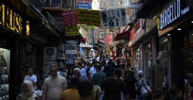 People walk along a street market at Eminönü commercial area in Istanbul, Aug. 23, 2023. (AP Fıle Photo)