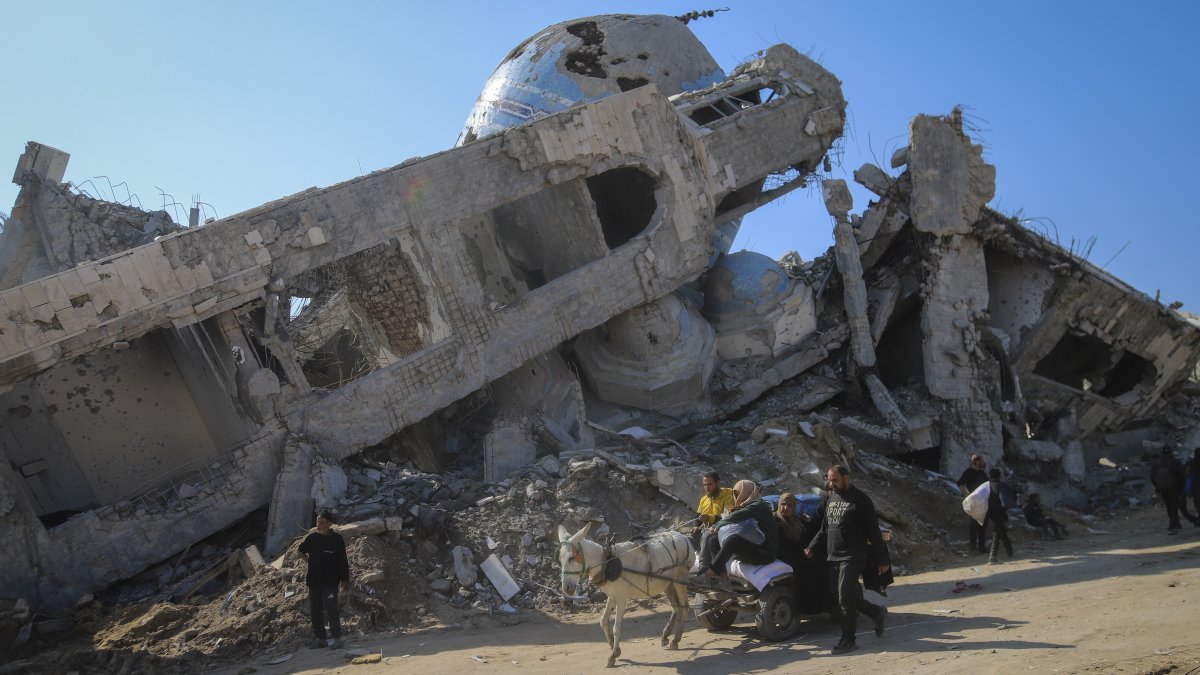 A family rides in a horse-drawn cart past a destroyed mosque in Beit Lahia, northern Gaza Strip, Jan. 29, 2025. (AP Photo)