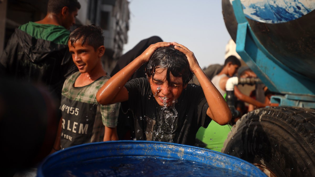 A Palestinian young man rinses his head with water amidst soaring temperatures in western Gaza City, Palestine, Aug. 13, 2025. (Getty Images)