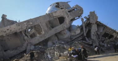 A family rides in a horse-drawn cart past a destroyed mosque in Beit Lahia, northern Gaza Strip, Jan. 29, 2025. (AP Photo)