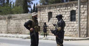 A member of the government security forces (L) speaks with a YPG terrorist during a prisoner exchange, Aleppo, Syria, June 2, 2025. (AP Photo)