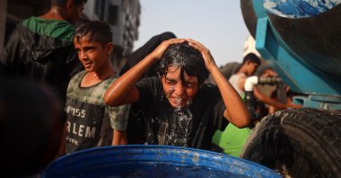 A Palestinian young man rinses his head with water amidst soaring temperatures in western Gaza City, Palestine, Aug. 13, 2025. (Getty Images)