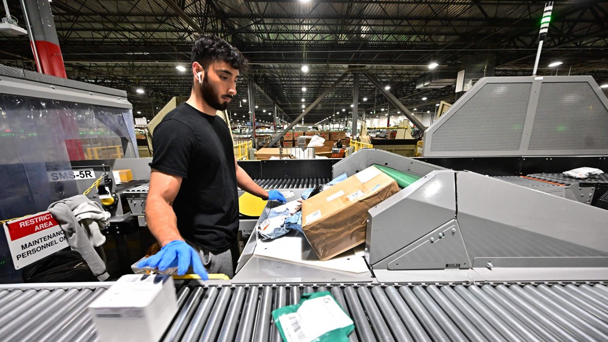 A postal worker sorts packages during a media tour hosted by the U.S. Postal Service at the Los Angeles Processing and Distribution Center, the largest in the country, Nov. 30, 2023. (AFP Photo)