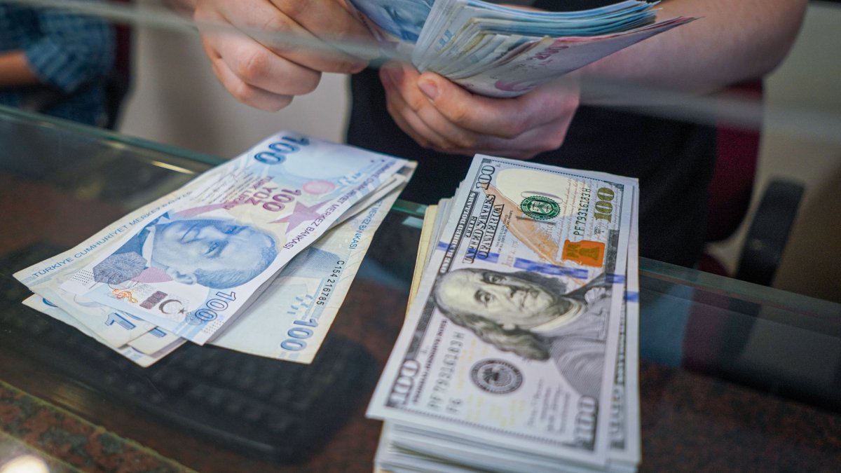 A man in the exchange office counts Turkish lira next to U.S. dollar banknotes, Ankara, Türkiye, June 13, 2022. (Reuters Photo) 