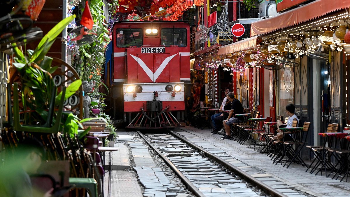A train passes along a railway track between cafe terraces in central Hanoi, Vietnam, Aug. 18, 2025. (AFP Photo)