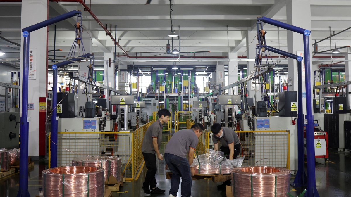 Employees move copper rod on a pallet on the production line for copper flat wire at the Wellascent factory in Ganzhou, Jiangxi province, China, Aug. 14, 2025. (Reuters Photo)