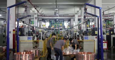 Employees move copper rod on a pallet on the production line for copper flat wire at the Wellascent factory in Ganzhou, Jiangxi province, China, Aug. 14, 2025. (Reuters Photo)