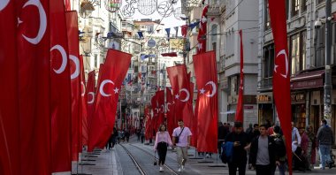 People walk along Istiklal Avenue, decorated with Turkish national flags, Istanbul, Türkiye, Oct. 27, 2023. (Reuters Photo)