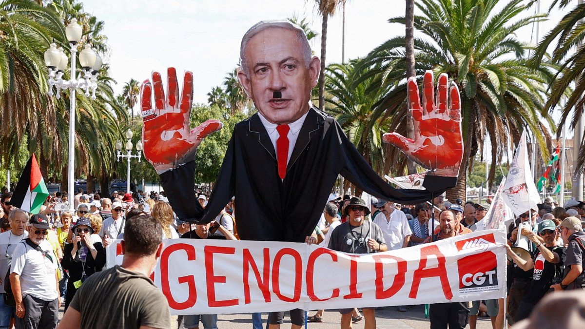 Demonstrators hold a banner reading, &quot;Genocide&quot; and an image of Israeli Prime Minister Benjamin Netanyahu with a Hitler moustache and bloody palms, before the Global Sumud Flotilla, a humanitarian expedition to Gaza sets sail, port of Barcelona, Spain, Aug. 31, 2025. (Reuters Photo)