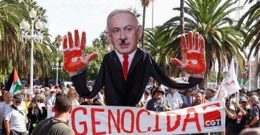 Demonstrators hold a banner reading, &quot;Genocide&quot; and an image of Israeli Prime Minister Benjamin Netanyahu with a Hitler moustache and bloody palms, before the Global Sumud Flotilla, a humanitarian expedition to Gaza sets sail, port of Barcelona, Spain, Aug. 31, 2025. (Reuters Photo)