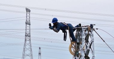 A worker of a power supply company installs a power grid in Majiatan, northern Ningxia region, China, Aug. 23, 2025. (AFP Photo)