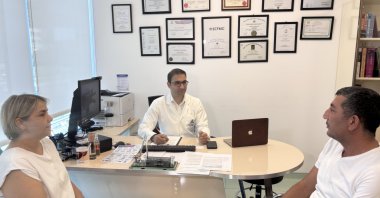 Deniz Ağca (L) and her husband Ismail Ağca pose with Dr. Veysel Umman at Yeditepe University Koşuyolu Hospital, Istanbul, Türkiye, Sept. 1, 2025. (DHA Photo)