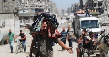 A displaced Palestinian carries belongings, as he flees amid an Israeli military operation, in Gaza City, Sept. 1, 2025. (Reuters Photo)
