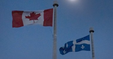 The moon covers the sun during a total solar eclipse, as Canadian and Quebec flags fly, as seen from Bishop's University in Sherbrooke, Quebec, Monday, April 8, 2024. (AP File Photo)