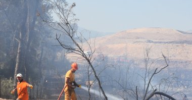 Teams try to control a fire near a forest in the Kepez district through aerial and ground intervention, Antalya, Türkiye, Aug. 12, 2025. (AA Photo)