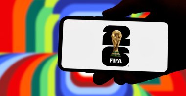 A silhouette hand holds a phone with the 2026 FIFA World Cup logo, Guilherand-Granges, France, June 16, 2025. (Shutterstock Photo)