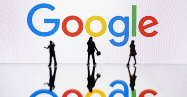 This illustration photograph shows figurines next to a screen displaying a logo of Google, Mulhouse, eastern France, Oct. 30, 2023. (AFP Photo)
