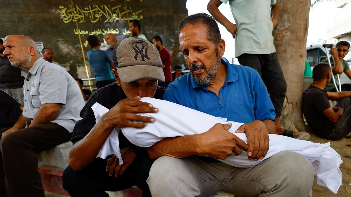 Relatives embrace a child victim, who is part of a group of Palestinians killed in overnight Israeli strikes during their funeral at Al-Shifa Hospital in Gaza City, Palestine, Sept. 5, 2025. (Reuters Photo)