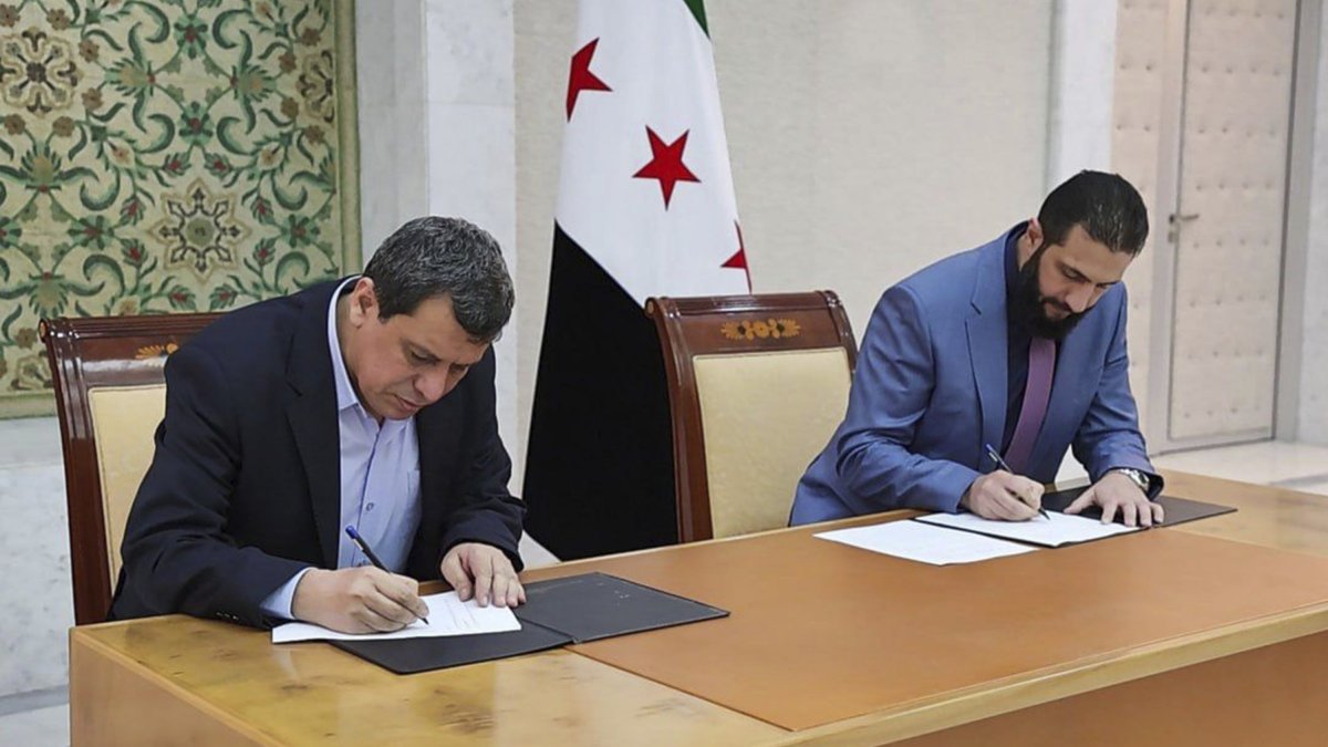 Syrian interim President Ahmad al-Sharaa (R) and YPG leader Ferhat Abdi Şahin sign a deal, Damascus, Syria, March 10, 2025. (SANA via AP Photo)