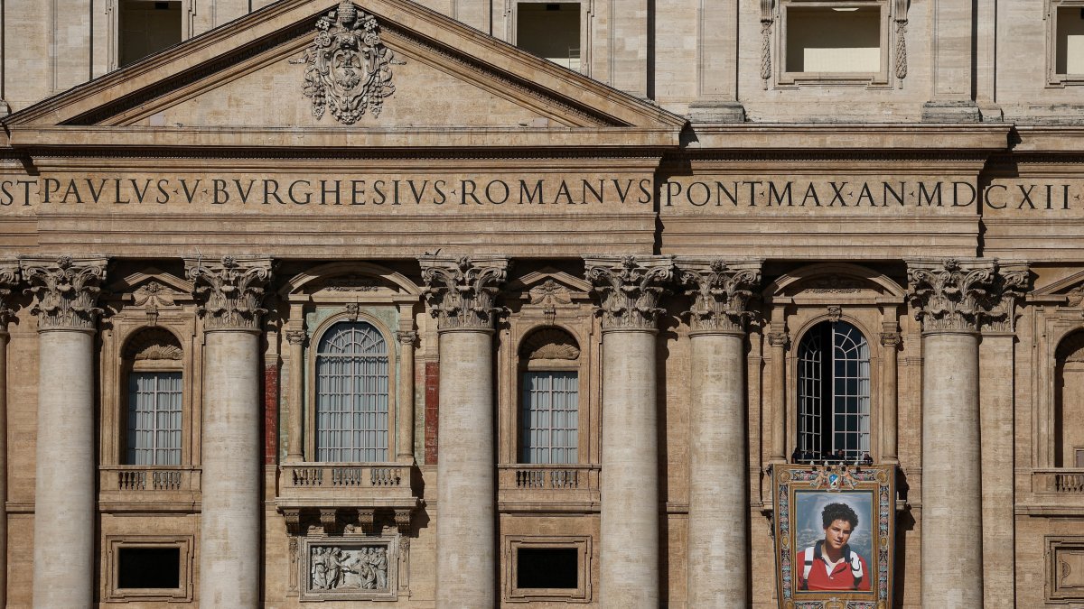 Workers install a tapestry on the facade of St. Peter&#039;s Basilica at the Vatican depicting an image of Carlo Acutis, as seen from Rome, Italy, Sept. 4, 2025. (Reuters Photo)